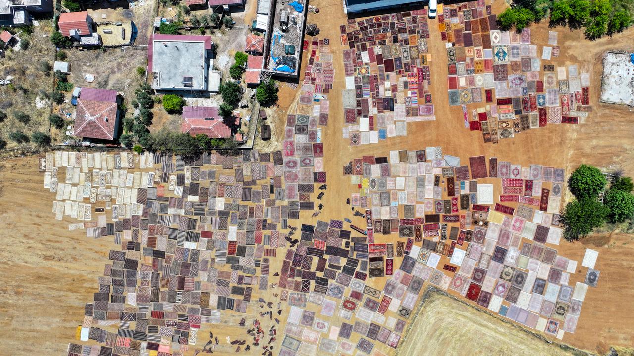 An aerial view shows handwoven carpets laid out in the open fields of Dosemealti district in Antalya, Türkiye, to naturally soften their colors under the sun, on June 18, 2025. (AA Photo)