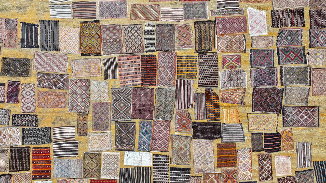 An aerial view shows handwoven carpets laid out in the open fields of Dosemealti district in Antalya, Türkiye, to naturally soften their colors under the sun, on June 18, 2025. (AA Photo)