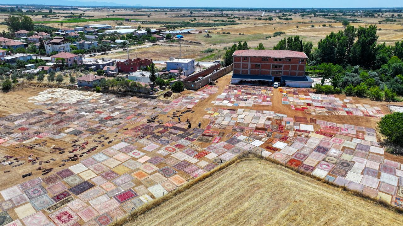 An aerial view shows handwoven carpets laid out in the open fields of Dosemealti district in Antalya, Türkiye, to naturally soften their colors under the sun, on June 18, 2025. (AA Photo)