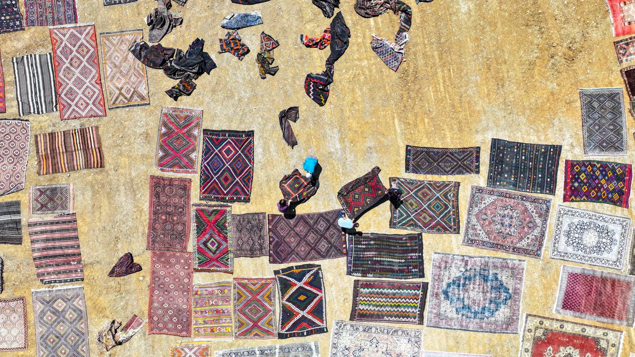 An aerial view shows handwoven carpets laid out in the open fields of Dosemealti district in Antalya, Türkiye, to naturally soften their colors under the sun, on June 18, 2025. (AA Photo)