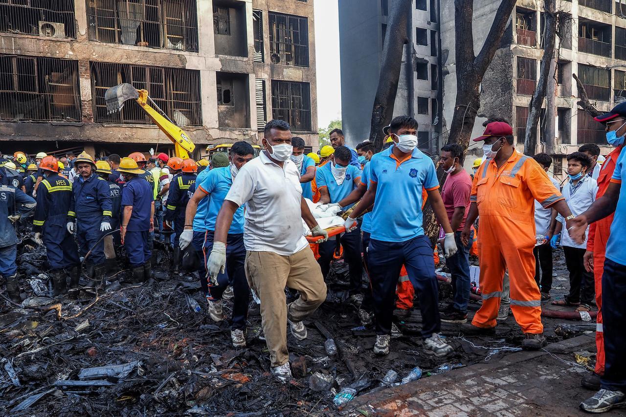 Rescue officials carry a victims body at the site where Air India flight 171 crashed in a residential area near the airport in Ahmedabad, Indi on June 12, 2025. (AFP Photo)