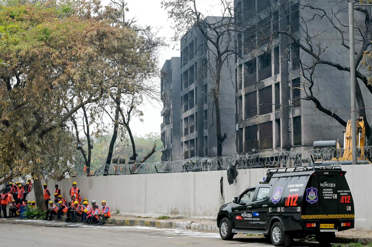 Workers wait to clear debris from the crash site of Air India flight 171, outside charred buildings at a residential area near the airport in Ahmedabad, India on June 16, 2025. (AFP Photo)