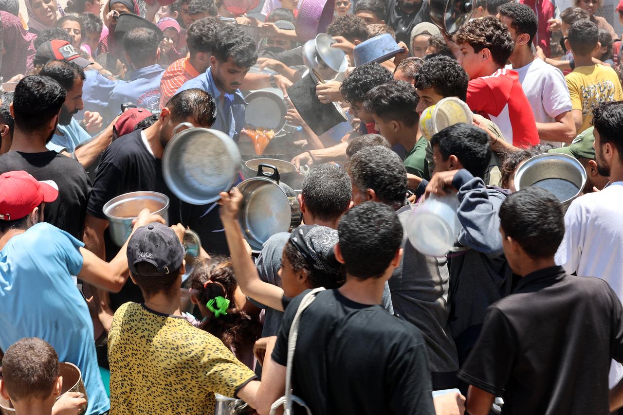 Palestinians try to get food at a charity kitchen providing hot meals in Rimal neighbourhood in Gaza City on June 18, 2025. (AFP Photo)