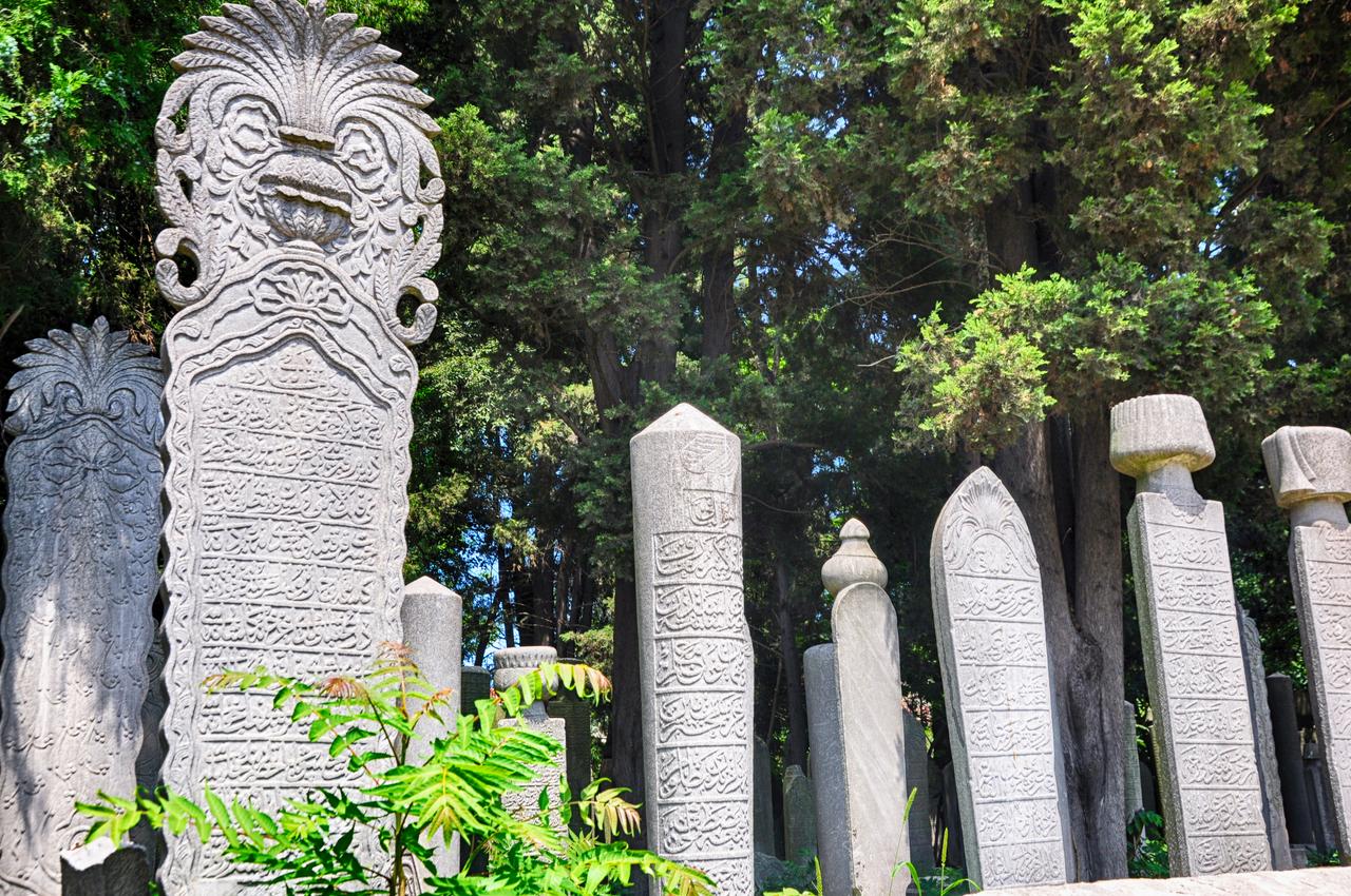 Carved Ottoman-era gravestones stand within a historic cemetery in Eyupsultan Cemetary Istanbul, Türkiye. (Adobe Stock Photo)