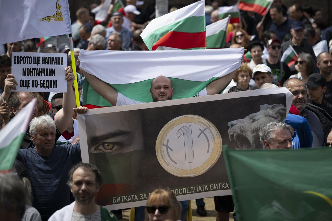A protester waves a Bulgarian national flag behind a poster featuring a lev coin during an anti-eurozone rally in Sofia on May 31, 2025. (AFP Photo)