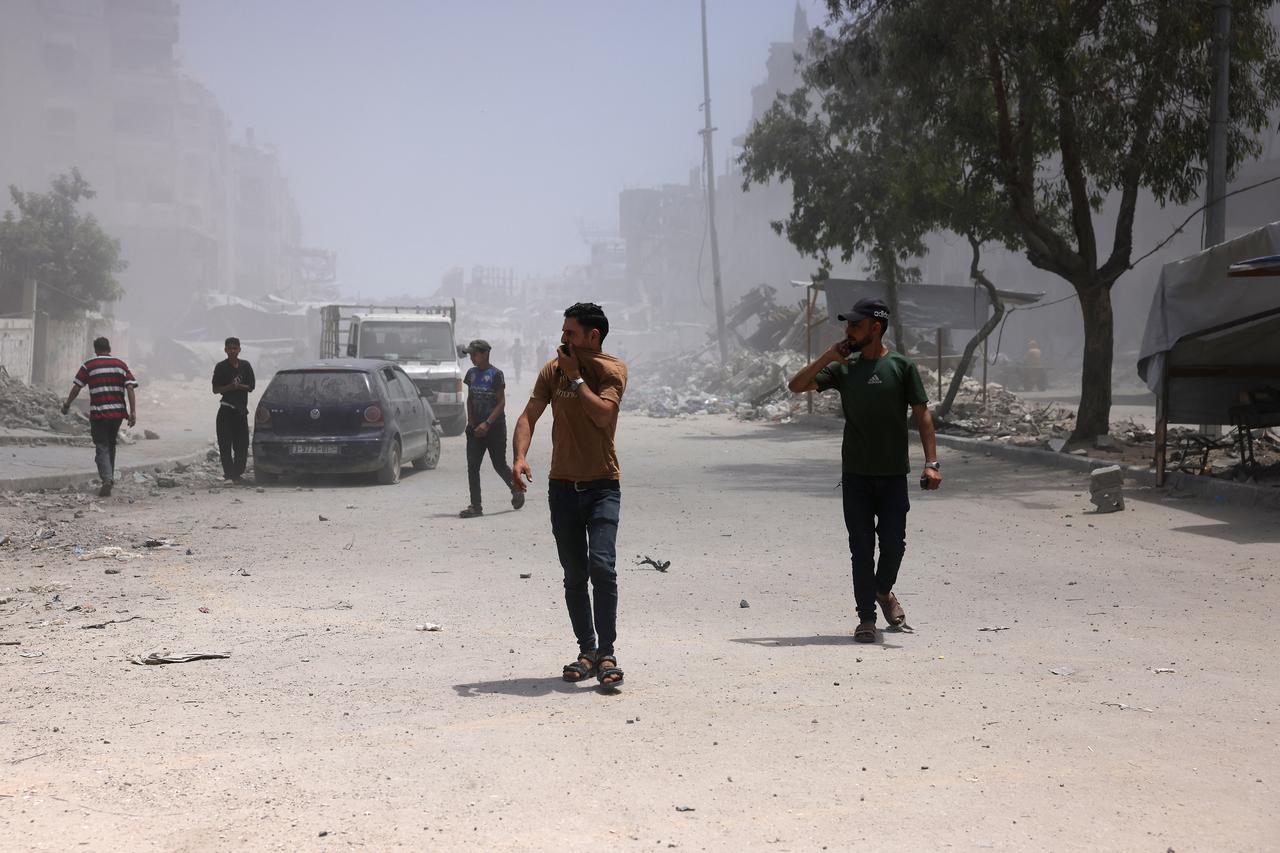Palestinians cover their faces as they walk amid dust and smoke after an Israeli strike hit a nearby house west of Jabalia, in the northern Gaza Strip, on June 1, 2025. (AFP Photo)