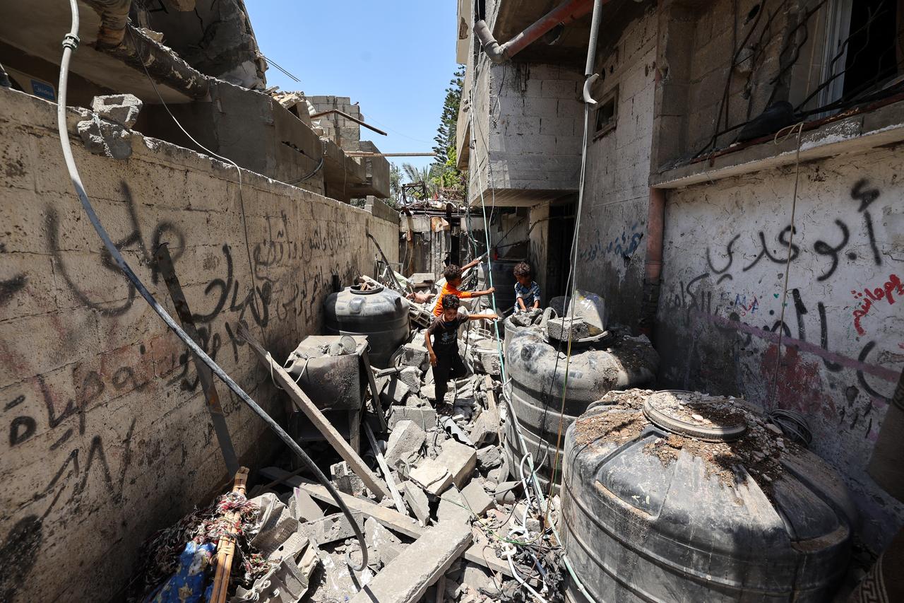 Children look for salvageable items at the site of an Israeli strike that targeted a house in the Nuseirat camp for Palestinian refugees in the central Gaza Strip on June 1, 2025. (Photo by Eyad BABA / AFP)