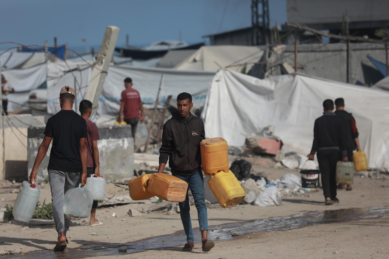 GAZA CITY, GAZA - JUNE 01: Palestinians, including children in western Gaza City carry filled containers with water distributed by a water tanker, amid ongoing Israeli attacks and the continued closure of border crossings, which have severely limited access to clean water in the Gaza Strip on June 01, 2025. ( Abdul Hakim Abu Riash - Anadolu Agency )