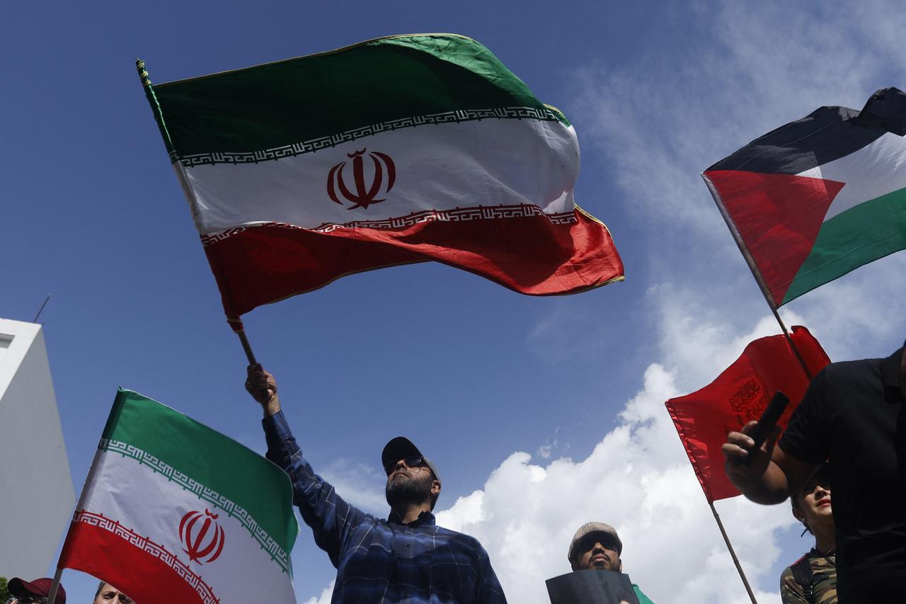 A man waves an Iranian flag during a rally against Israels attacks on Iran, in solidarity with the Palestinian people and to call for world peace in Caracas, on June 19, 2025. (Photo by Pedro MATTEY / AFP)