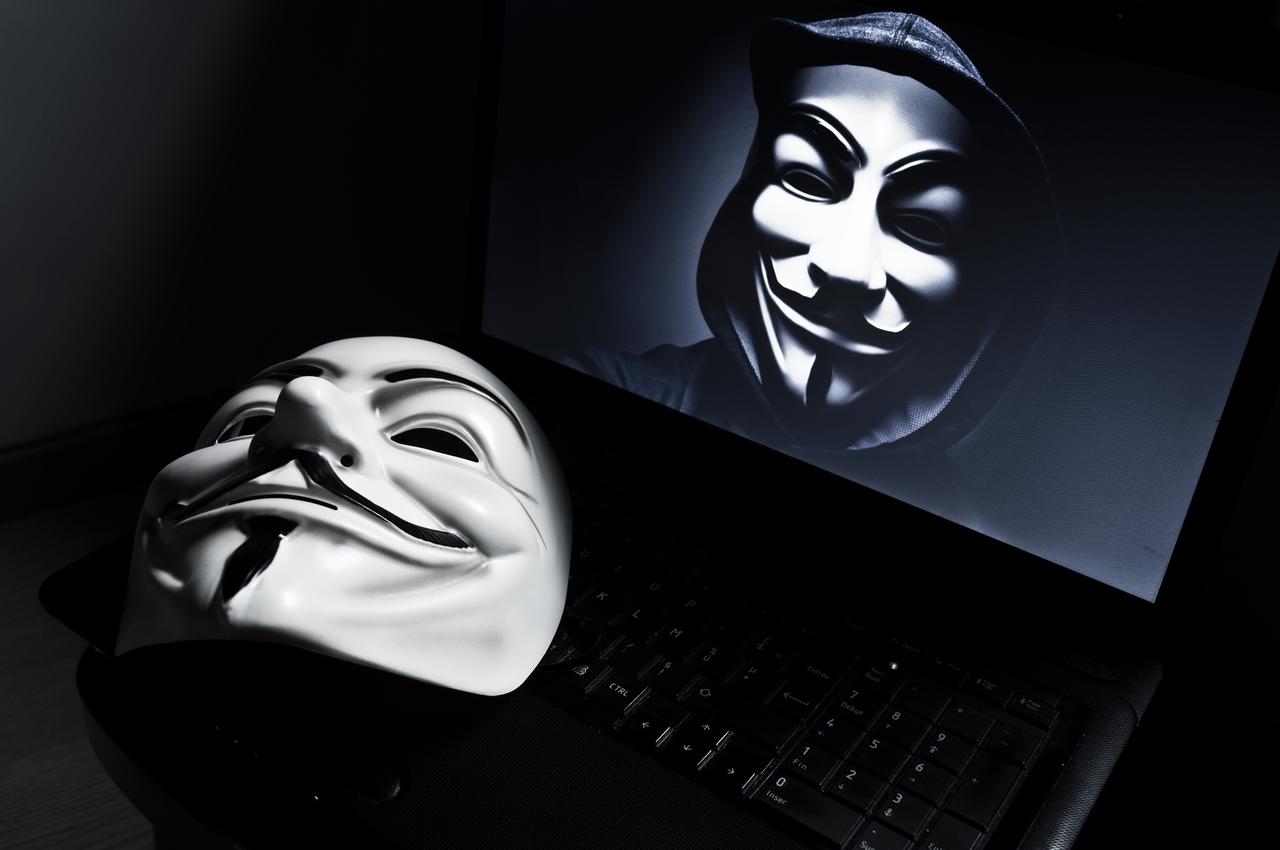 Vendetta mask appears on computer screen with anonymous member, symbolizing well-known online hacker group Anonymous.. (Adobe Stock Photo)