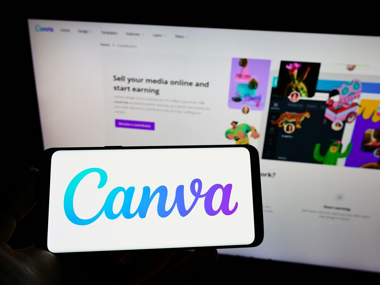 Photo illustration shows a person holding a smartphone displaying the Canva logo in front of the platform’s website in Stuttgart, Germany, on January 15, 2025. (Adobe Stock Photo)