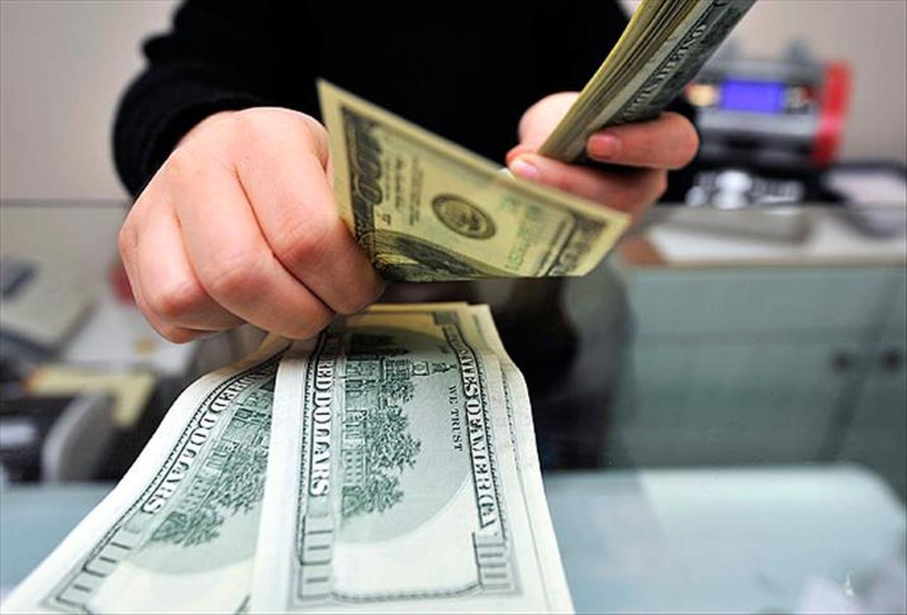 A person counts US dollar banknotes at a currency exchange desk in Türkiye, accessed on June 21, 2025. (AA Photo)