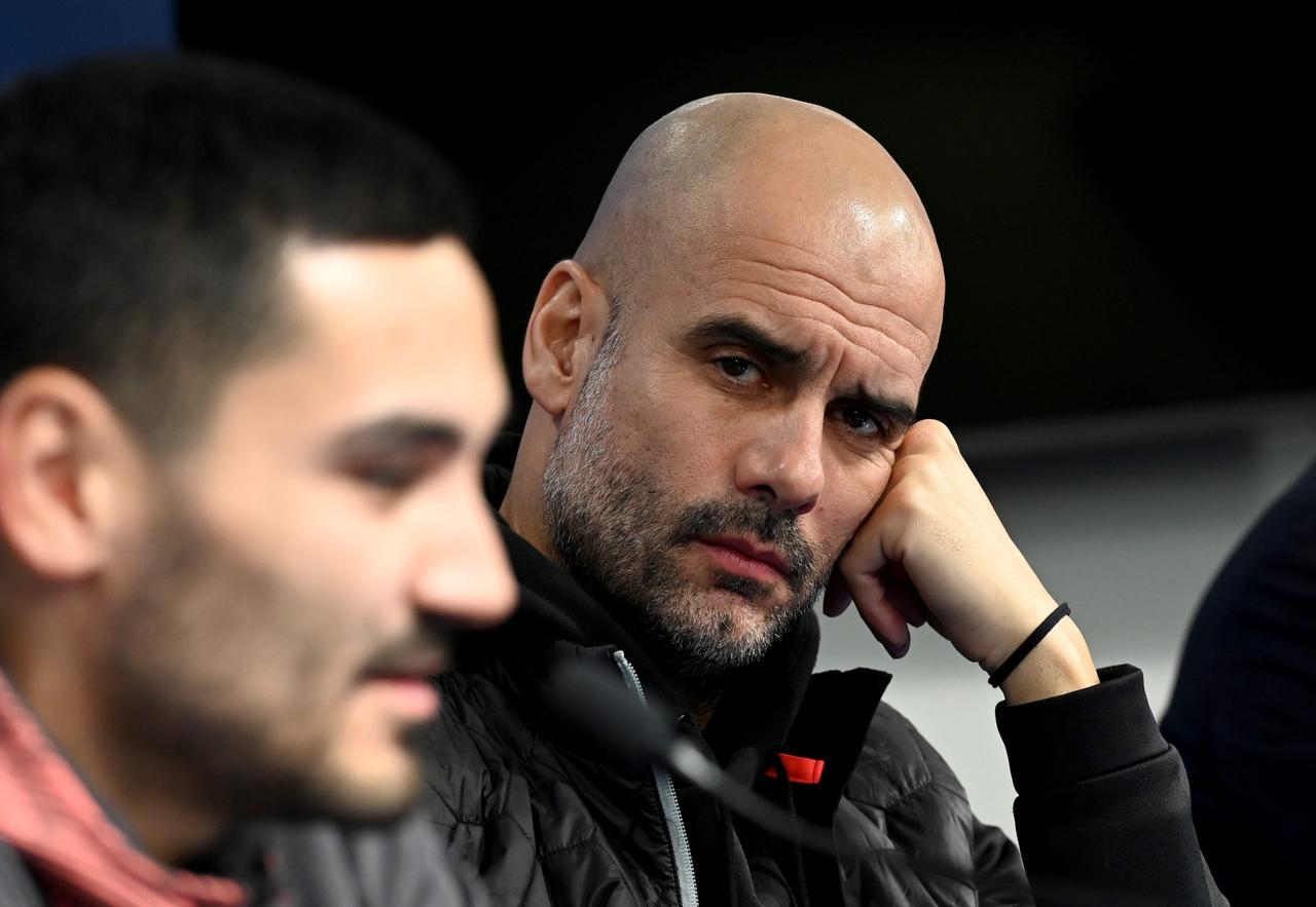 Manchester City head coach Pep Guardiola (R) looks to his midfielder Ilkay Gundogan during a press conference at the Maksimir stadium in Zagreb on December 10, 2019. (AFP Photo)