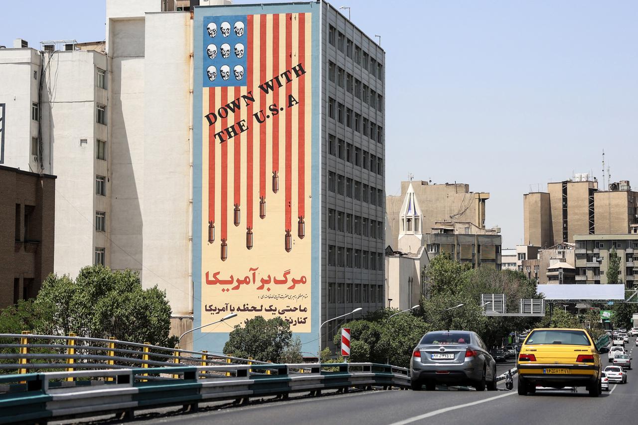 Commuters drive along a bridge near a building bearing a landmark anti-US mural in Tehran, on June 22, 2025. (AFP Photo)