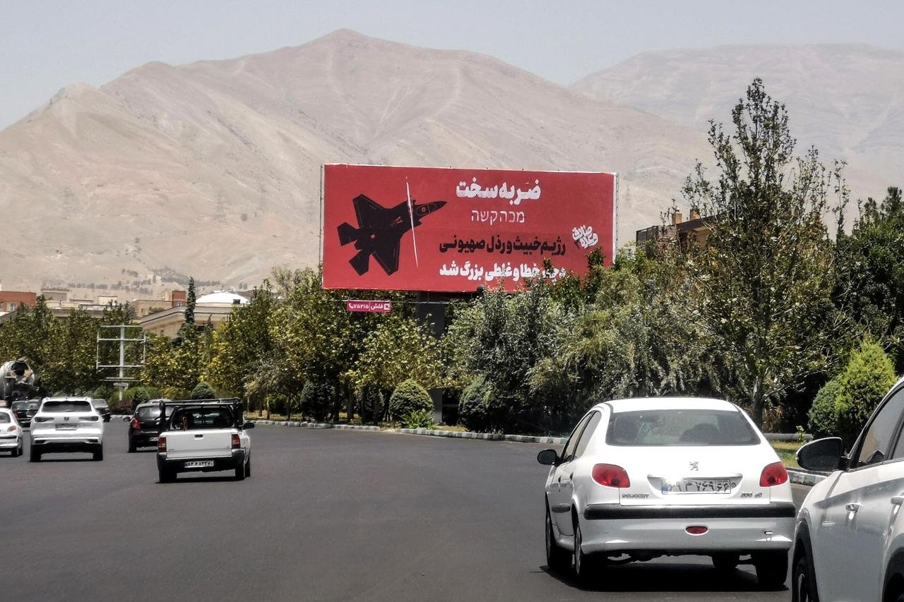 Commuters drive past an anti-Israel billboard in Tehran, on June 22, 2025. (AFP Photo)