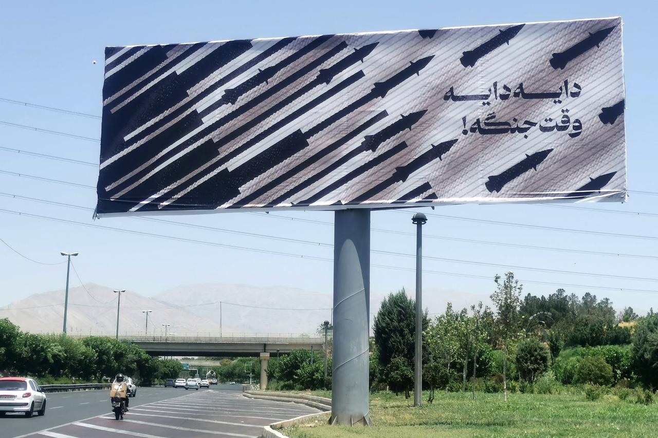 Commuters drive past an anti-Israel billboard in Tehran, on June 22, 2025. (AFP Photo)