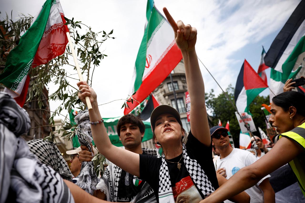 Protesters wave Palestinian and Iranian flags as they take part in a march through central London, on June 21, 2025. (AFP Photo)