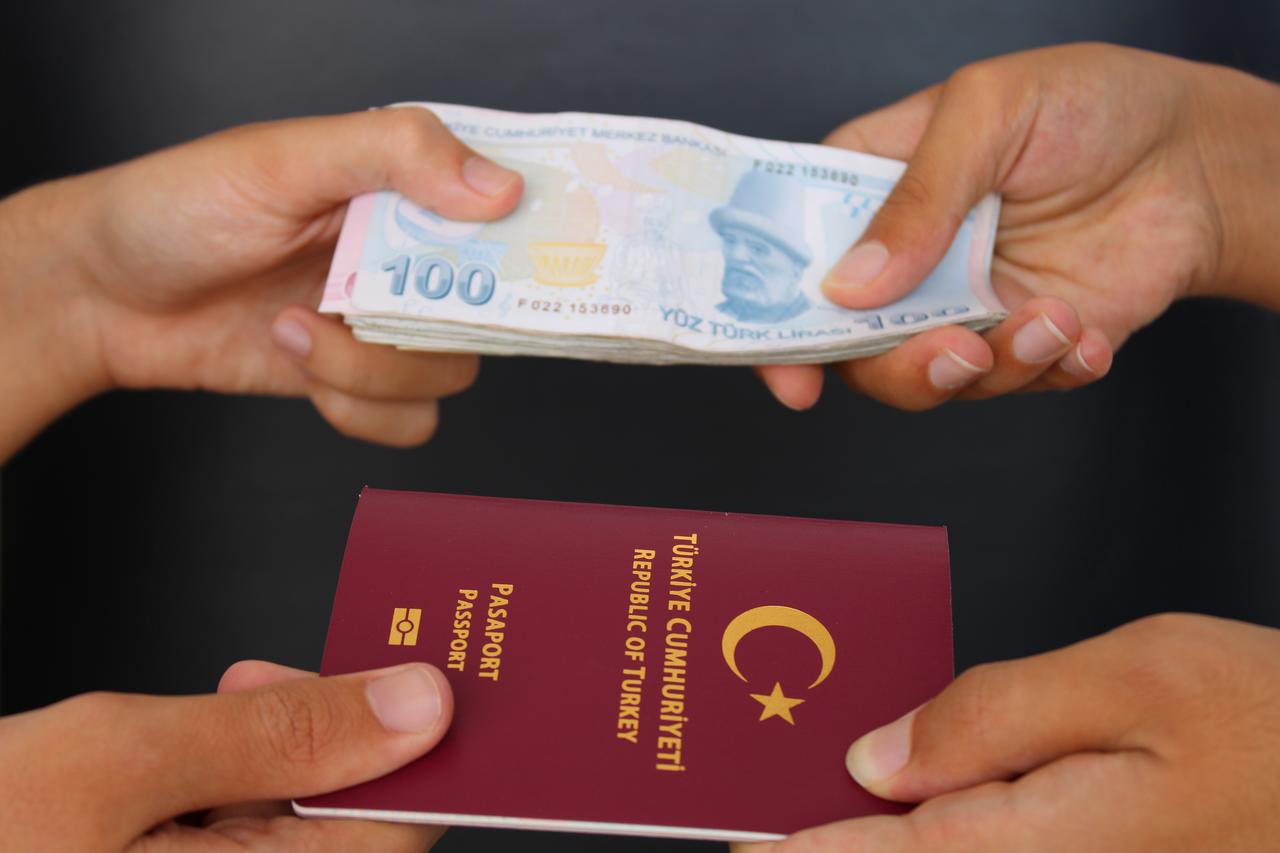 A visual representation of Türkiye’s investment citizenship route, showing hands exchanging Turkish lira and a passport, accessed on June 23, 2025. (Adobe Stock Photo)