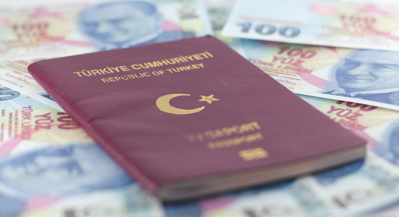 File photo shows a Turkish passport placed on 100-lira banknotes, accessed on June 23, 2025. (Adobe Stock Photo)