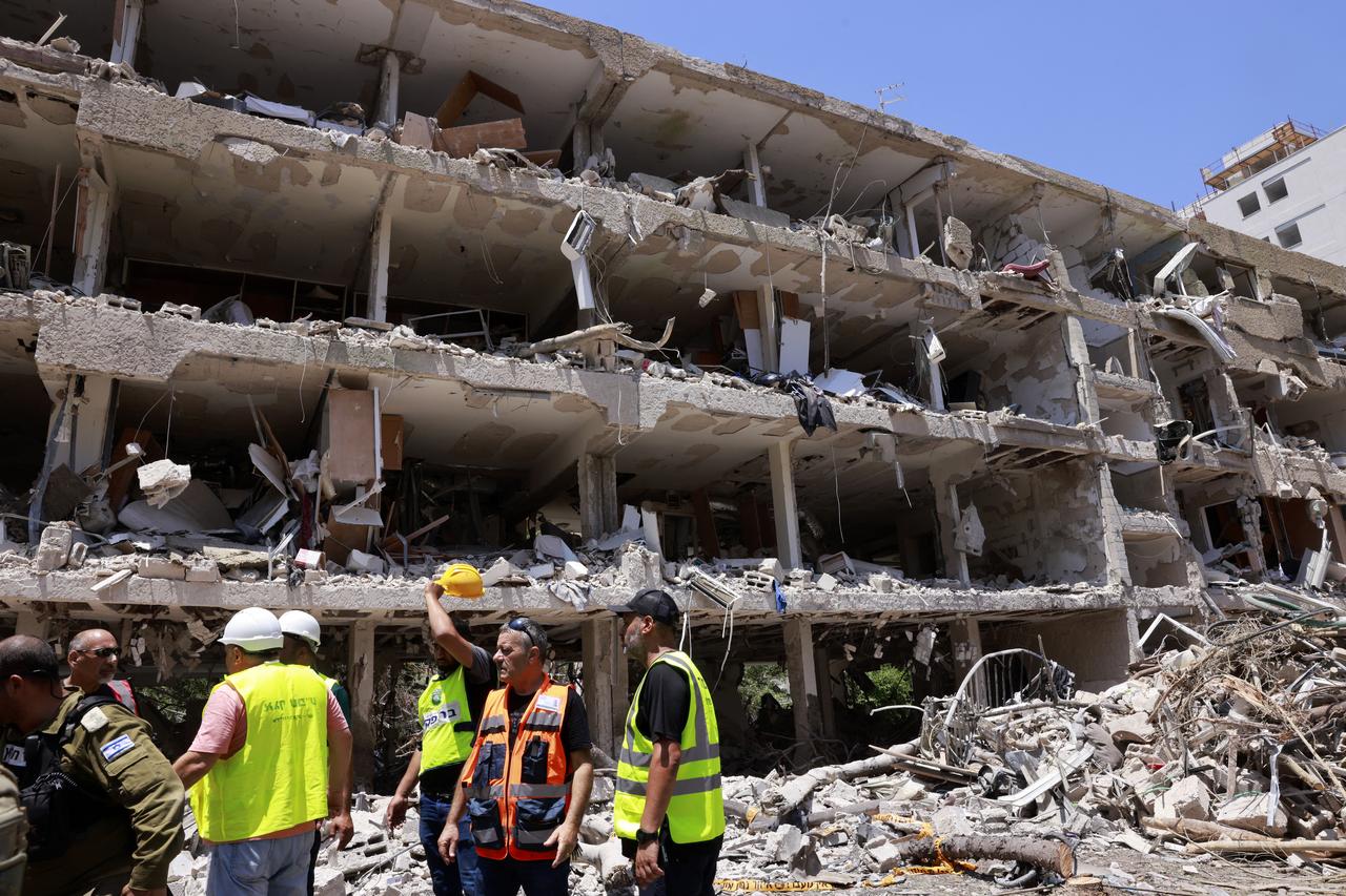 Israeli first responders gather in front of a building destroyed by an Iranian strike in Tel Aviv on June 22, 2025.  (AFP Photo)