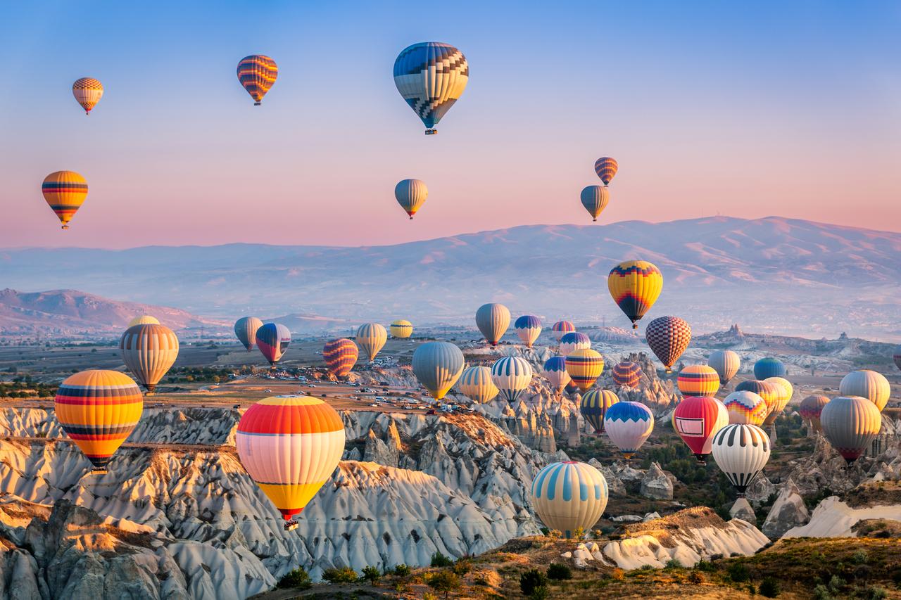 An aerial view of hot air balloons floating over Cappadocia, one of the most visited location from Türkiye. (Adobe Stock Photo)