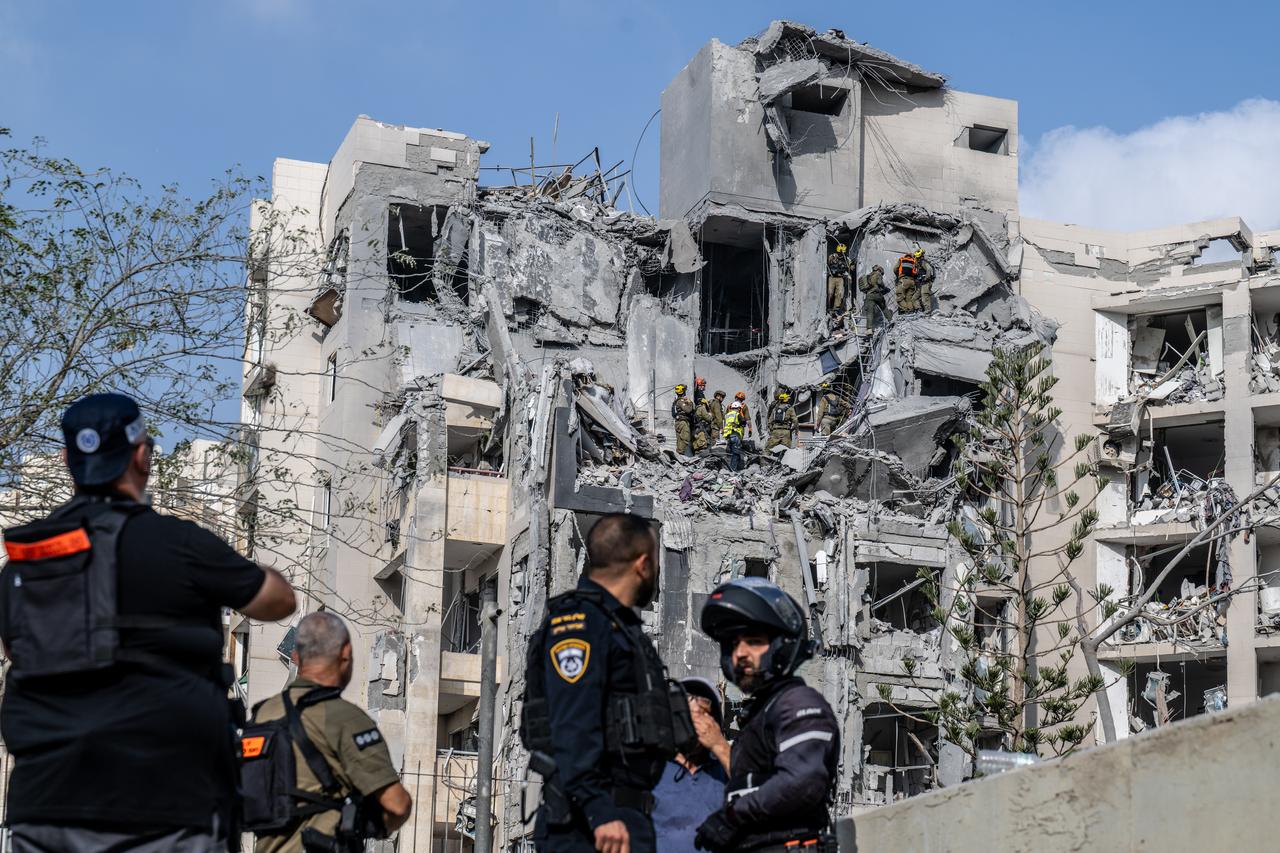 Search and rescue teams conduct search and rescue operations at a building that was heavily damaged and partially collapsed by a missile fired from Iran as police take security measures in Beersheba, Israel on June 24, 2025. (AA Photo)
