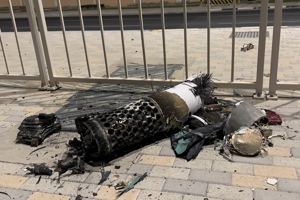 This frame grab take from AFPTV footage shows the remnants of an Iranian missile intercepted over Qatar, as it lies on a pavement near a fence on June 23, 2025. (AFP Photo)