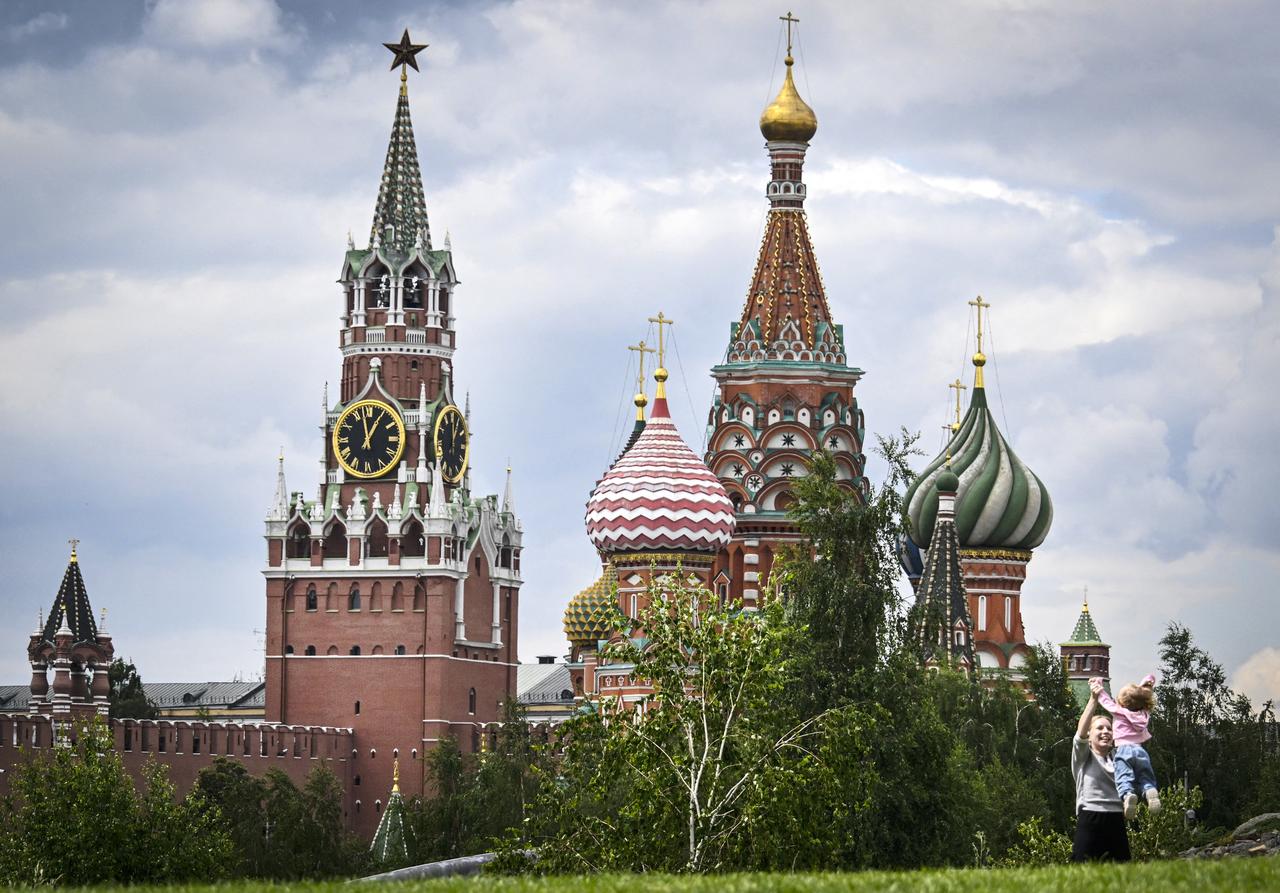 A family plays in front of the Kremlins Spasskaya tower and St. Basils cathedral in downtown Moscow on June 23, 2025. (AFP Photo)