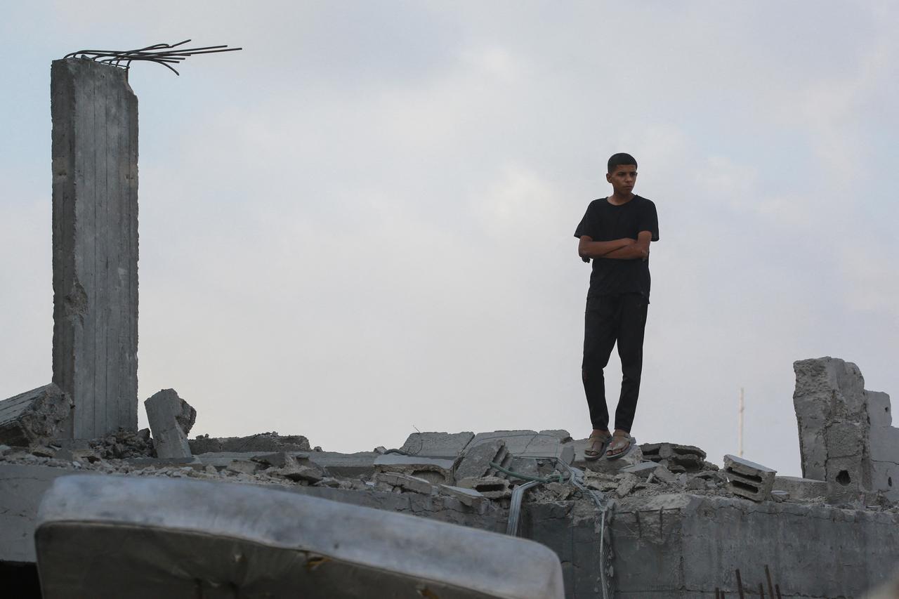 A Palestinian youth watches attempts to search for survivors and casualties in the rubble of the Abu Nadi home which was hit in an Israeli strike west of Jabalia in the northern Gaza Strip on June 23, 2025. (AFP Photo)