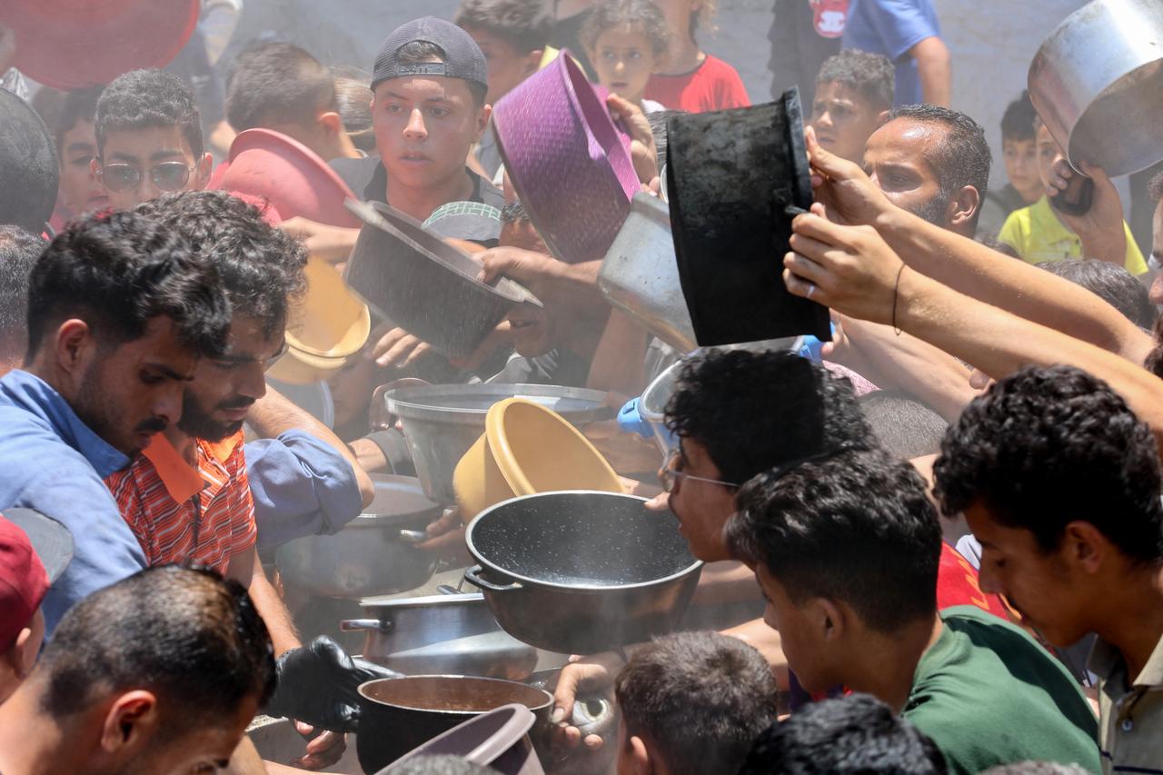 Palestinians try to get food at a charity kitchen providing hot meals in Rimal neighbourhood in Gaza City on June 18, 2025. (AFP Photo)