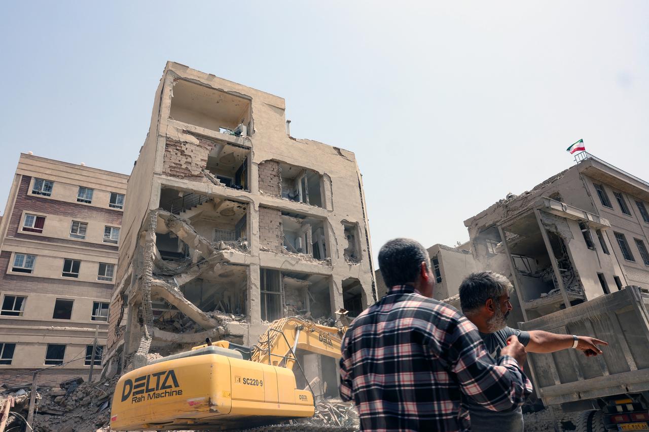 An excavator is used to clear the rubble in front of a building recently hit in Israeli strikes in Tehran on June 26, 2025, following a ceasefire with Israel that ended 12 days of fighting. (AFP Photo)