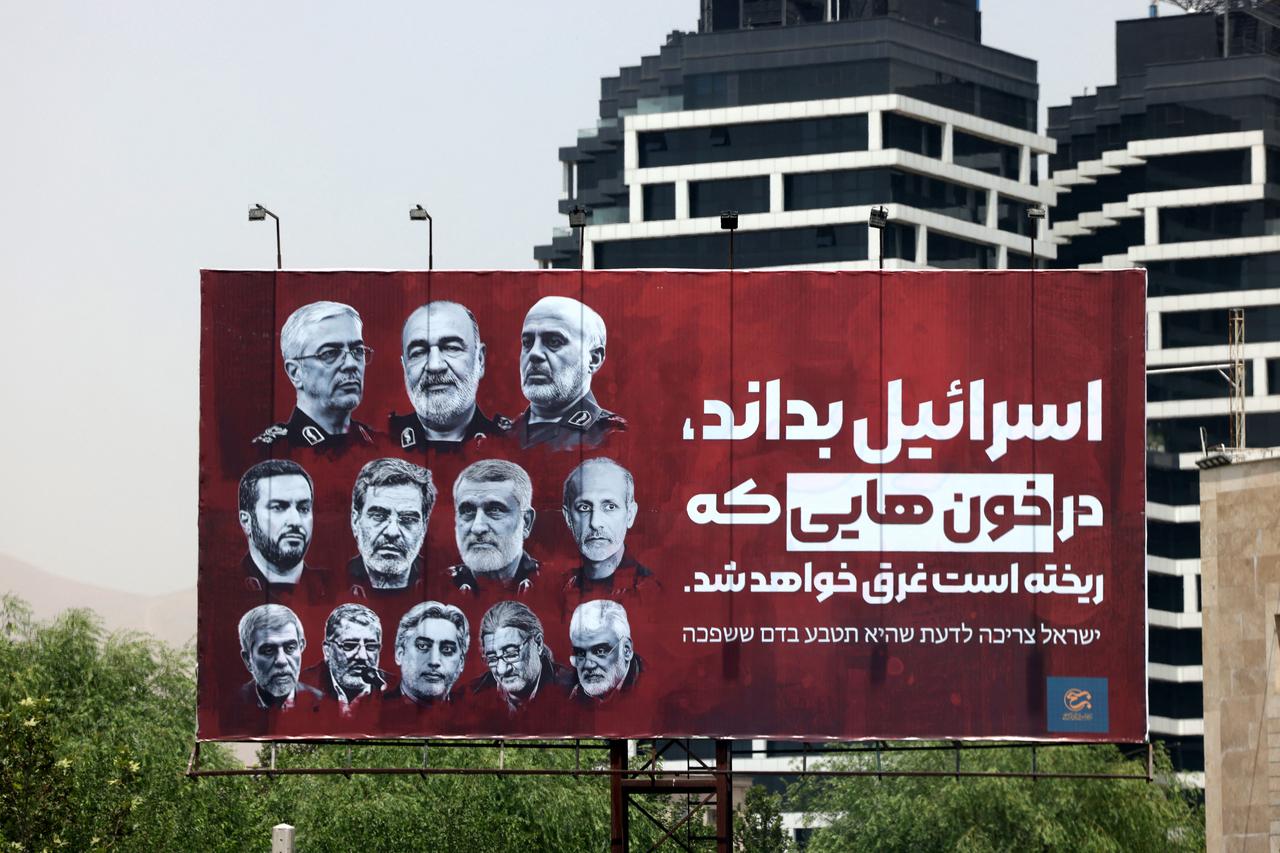 A billboard bearing pictures of Iranian senior military officials killed in recent Israeli attacks, is set up in a street in Tehran on June 26, 2025. Farsi slogan on billboard reads: "Israel should know that it will drown in the blood that it has spilled."  (AFP Photo)