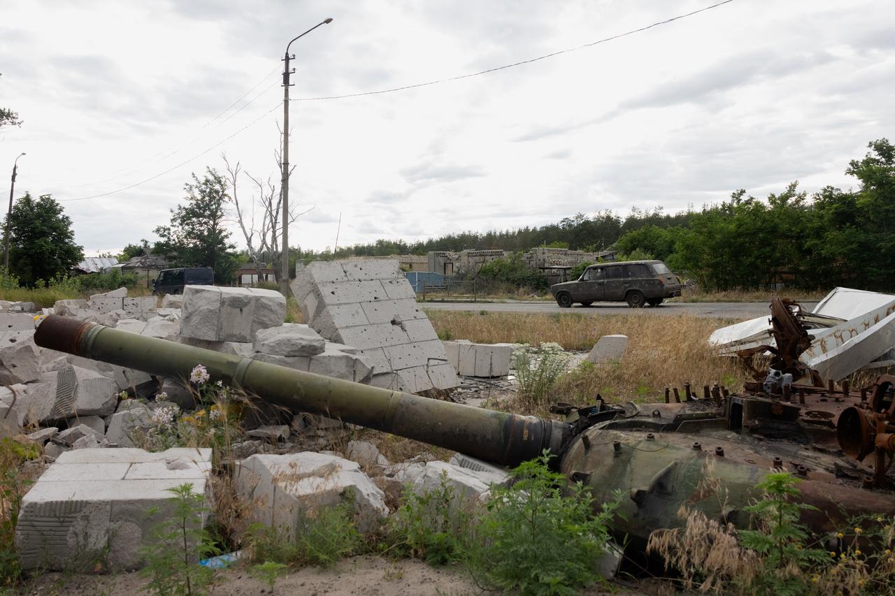 A car drives along the road past a partialy burnt tank in the city of Svyatohirs'k, Donetsk region on June 26, 2025. (AFP Photo)