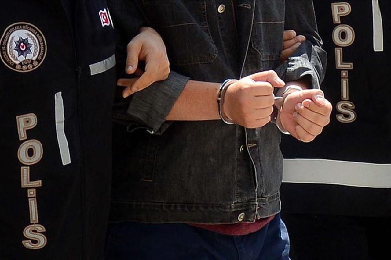 File photo shows a suspect in handcuffs, escorted by Turkish police officers. (AA Photo)