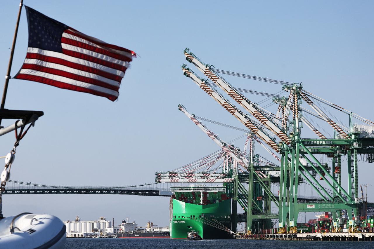 An American flag flies in front of shipping containers stacked on a container ship (C) at the Port of Los Angeles in Los Angeles, California, on June 25, 2025. (AFP Photo)