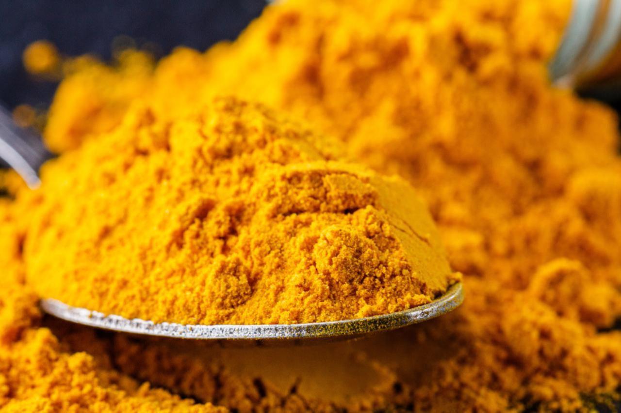 Natural turmeric powder on a dark stone background, accessed on June 2019,(Adobe Stock Photo)