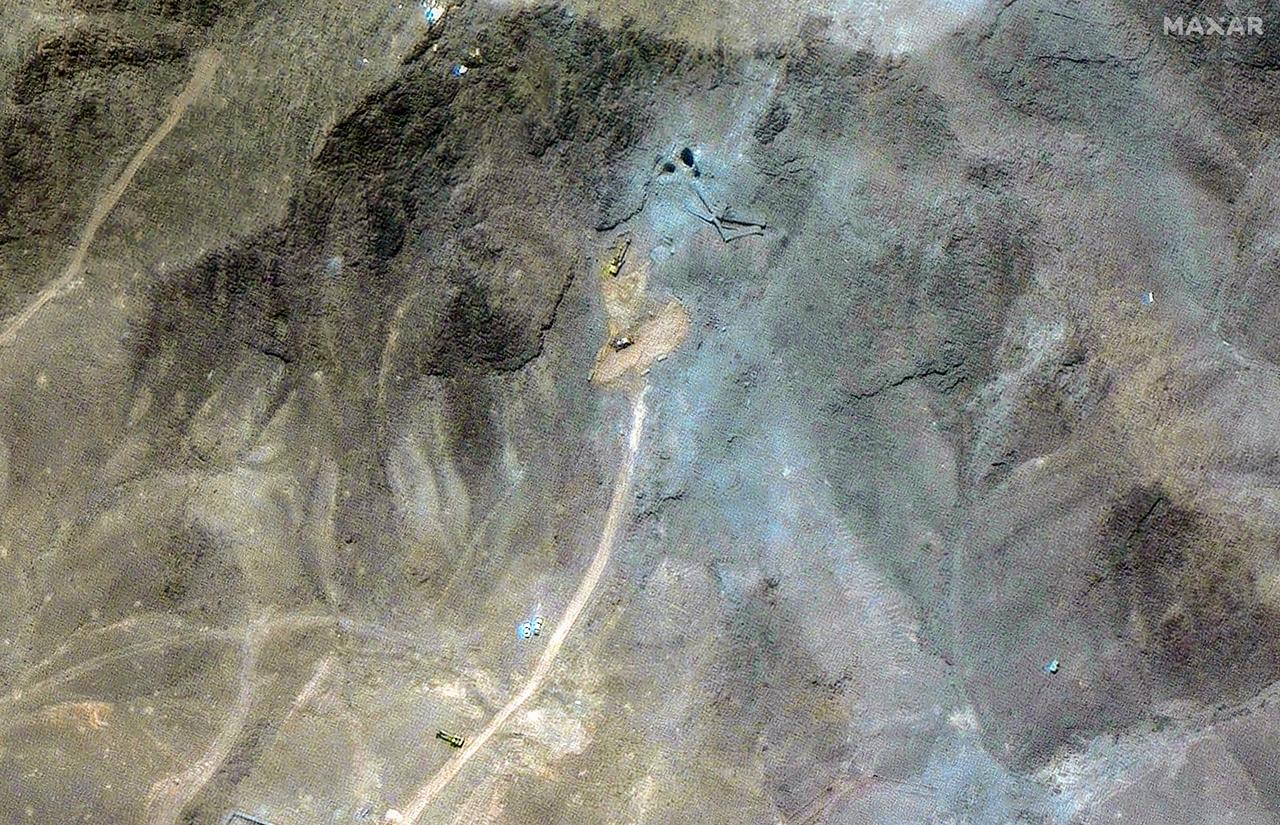 This handout satellite image provided by Maxar Technologies and dated June 27, 2025, shows excavators at the tunnel entrances of the Fordo Fuel Enrichment Plant (FFEP) one week after US strikes on three Iranian nuclear sites early on June 22.  (Photo by Satellite image ©2025 Maxar Technologies / AFP)