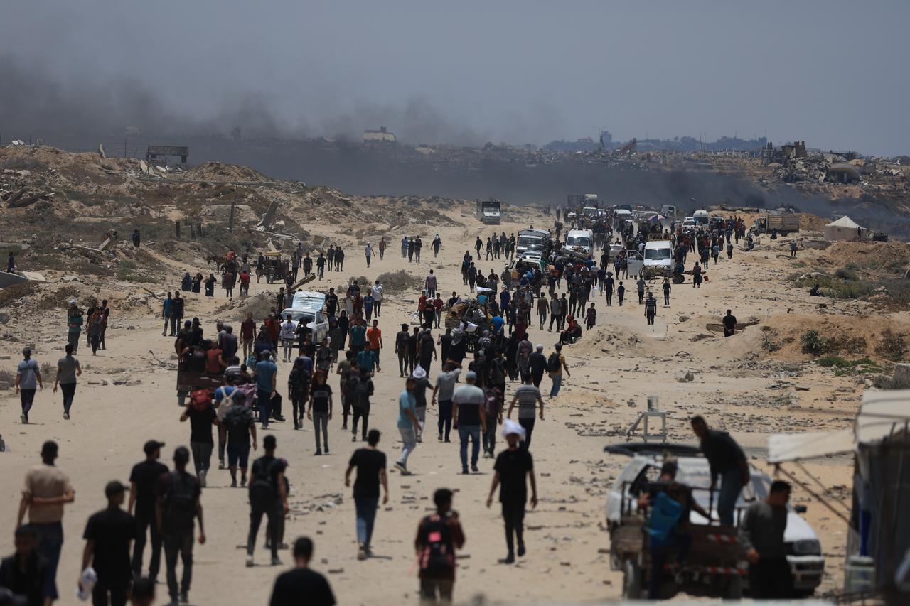 Palestinians walk toward the aid distribution point in the Netzarim Corridor under the shadow of widespread destruction in Gaza, Gaza on June 28, 2025. (AA Photo)