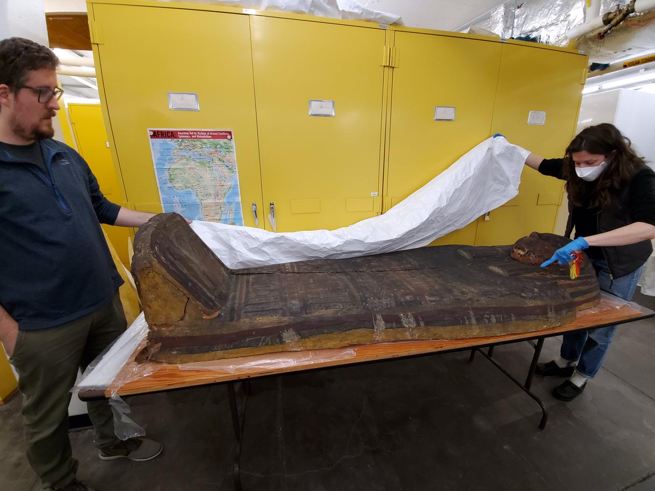 Researchers Travis Olds and Lisa Haney from the Carnegie Museum examine an ancient sarcophagus that was painted with Egyptian blue pigment. (Photo via Washington State University)