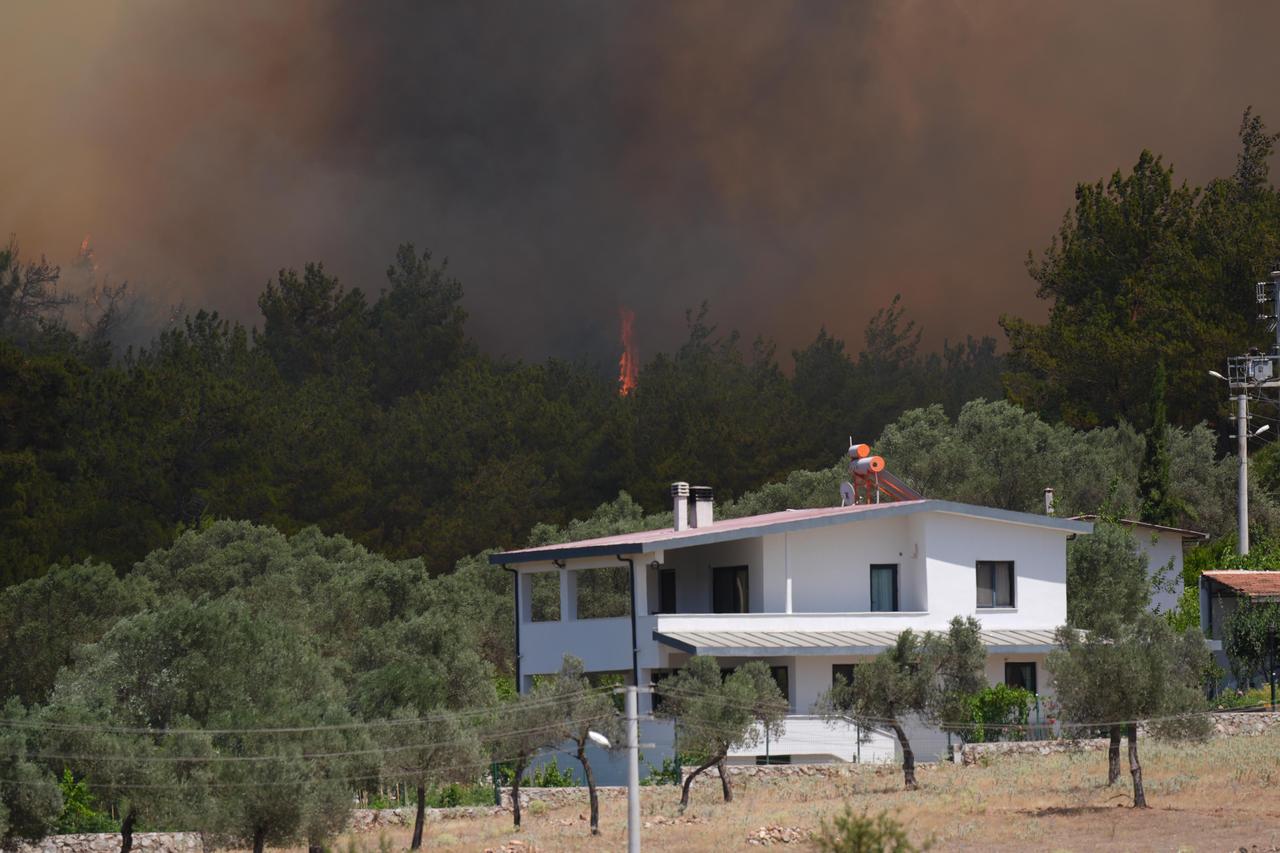 Smoke rises as firefighters respond to the blaze from the air and on the ground after a forest fire broke out along the borders of Menderes and Seferihisar districts in Izmir, Türkiye on June 29, 2025. (AA Photo)