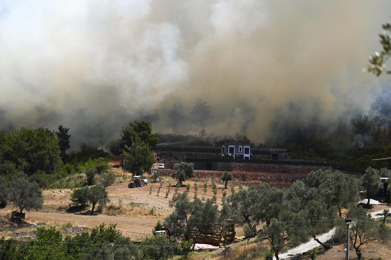 Smoke rises as firefighting efforts continue both from the air and on the ground in response to forest fires in the Menderes district of Izmir, Türkiye on June 30, 2025. (AA Photo)