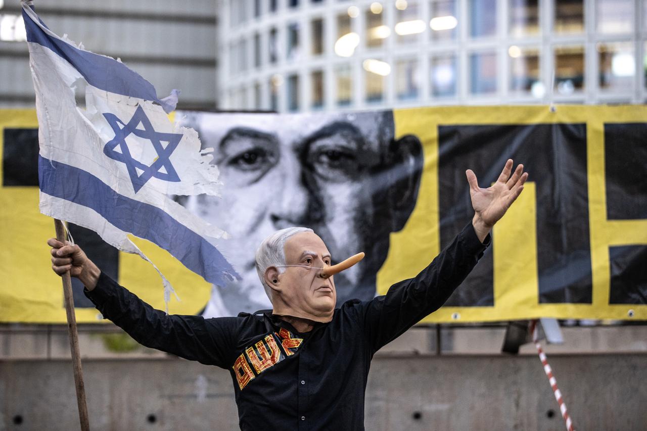 A protester wearing a Netanyahu mask holds an Israeli flag during a demonstration in Tel Aviv, Israel on May 31, 2025. (AA Photo)