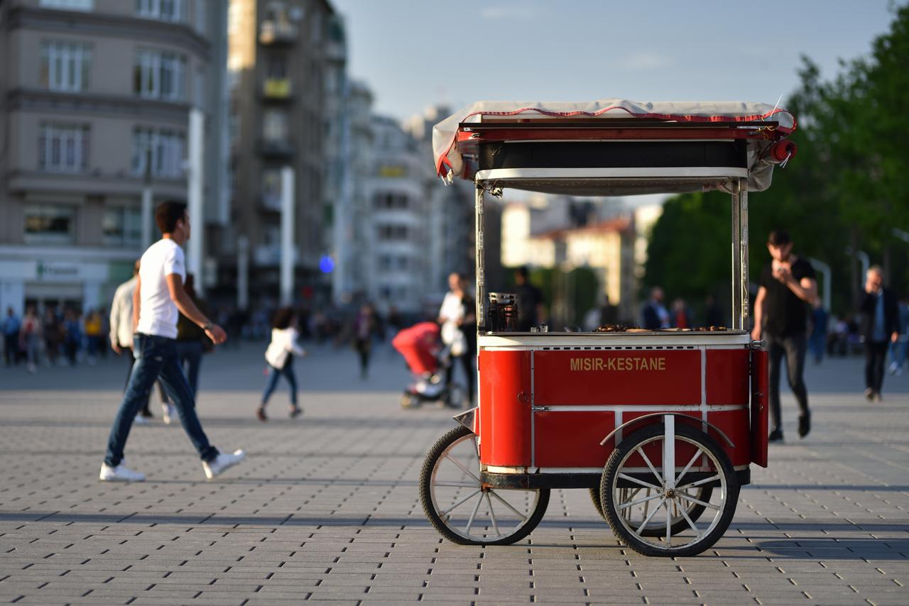 A traditional red street cart selling roasted corn and chestnuts stands in the middle of Taksim Square in Istanbul, Türkiye, accessed on June 5, 2025. (Adobe Stock Photo)