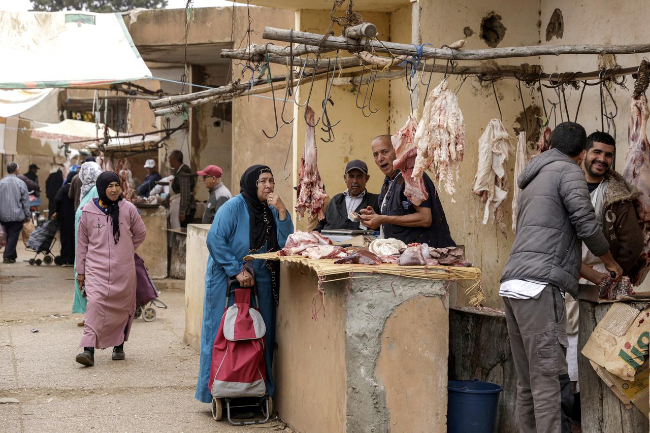 A woman shops for cuts of meat from a butcher at the weekly market in Khemisset in the Rabat region, about 100 kilometres east of the Moroccan capital, on June 3, 2025 amidst preparations ahead of Eid al-Adha, the Muslim feast of sacrifice. (AFP Photo)