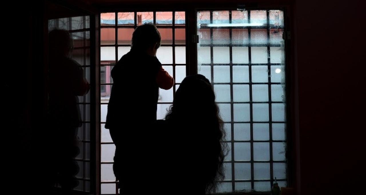 File photo shows a woman and her child looking out from behind barred windows inside a correctional facility in Türkiye. (IHA Photo)