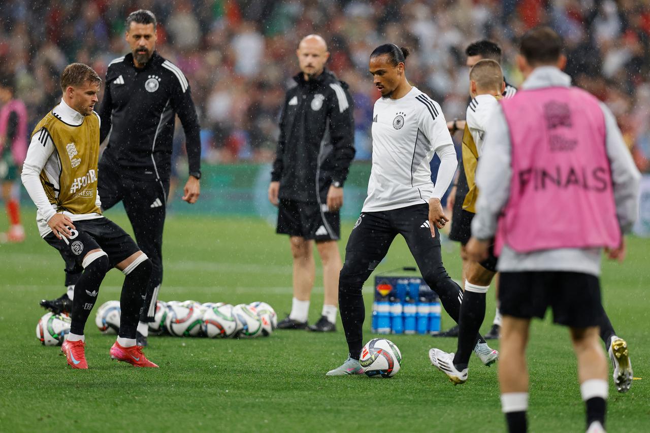 Germanys midfielder #19 Leroy Sane (C) and Germanys defender #18 Maxmilian Mittelstaedt (L) warm up prior to the UEFA Nations League semi-final football match between Germany and Portugal in Munich, southern Germany on June 4, 2025. (AFP Photo)
