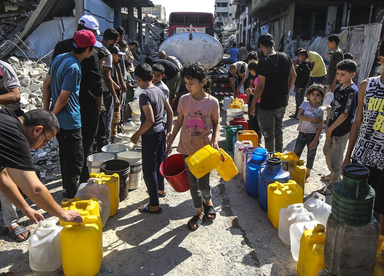 Palestinians, including children, queue with plastic containers to collect clean water from a tanker truck in a heavily damaged area of Gaza City, as they continue to face severe shortages of basic necessities such as shelter, food, and water amid ongoing Israeli attacks on Gaza on June 05, 2025. (AA Photo)