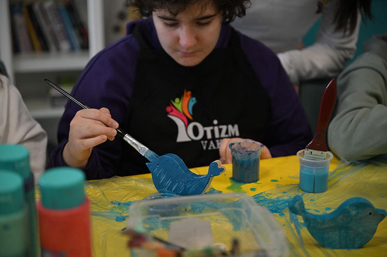 An autistic child paints a wooden figure during an art activity at the newly opened "Practice House" in Ankara, Türkiye, on January 18, 2025. (AA Photo)