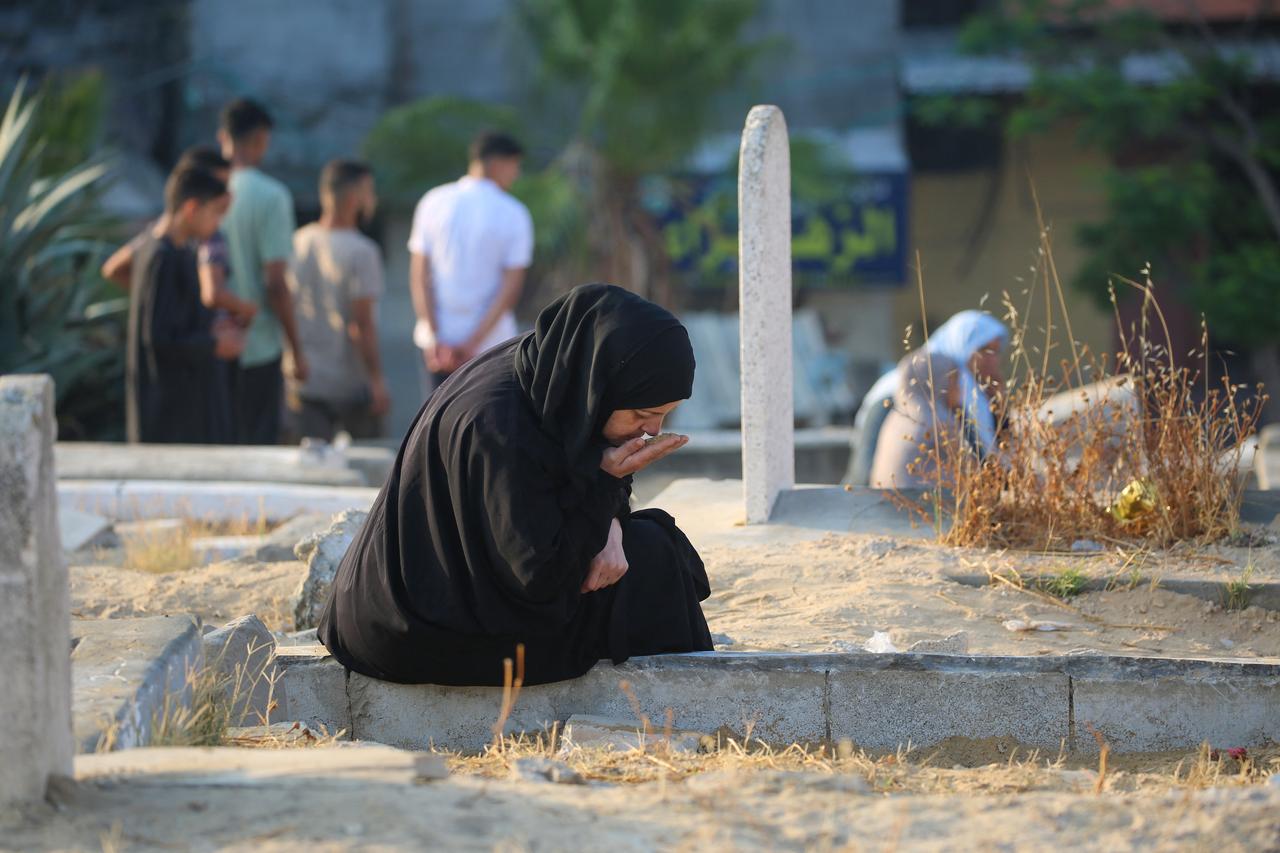 A woman prays at the grave of a loved one on the first day of the Muslim Eid al-Adha festival in Nuseirat, central Gaza Strip, on June 6, 2025. (AFP Photo)