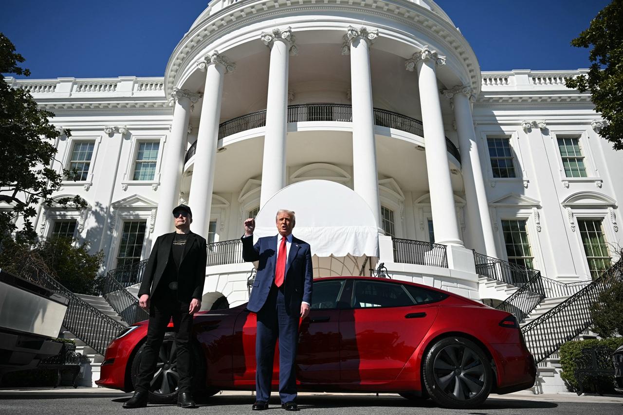 US President Donald Trump and Tesla CEO Elon Musk speak to the press as they stand next to a Tesla vehicle on the South Portico of the White House on March 11, 2025 in Washington, DC. (Photo by Mandel NGAN / AFP)